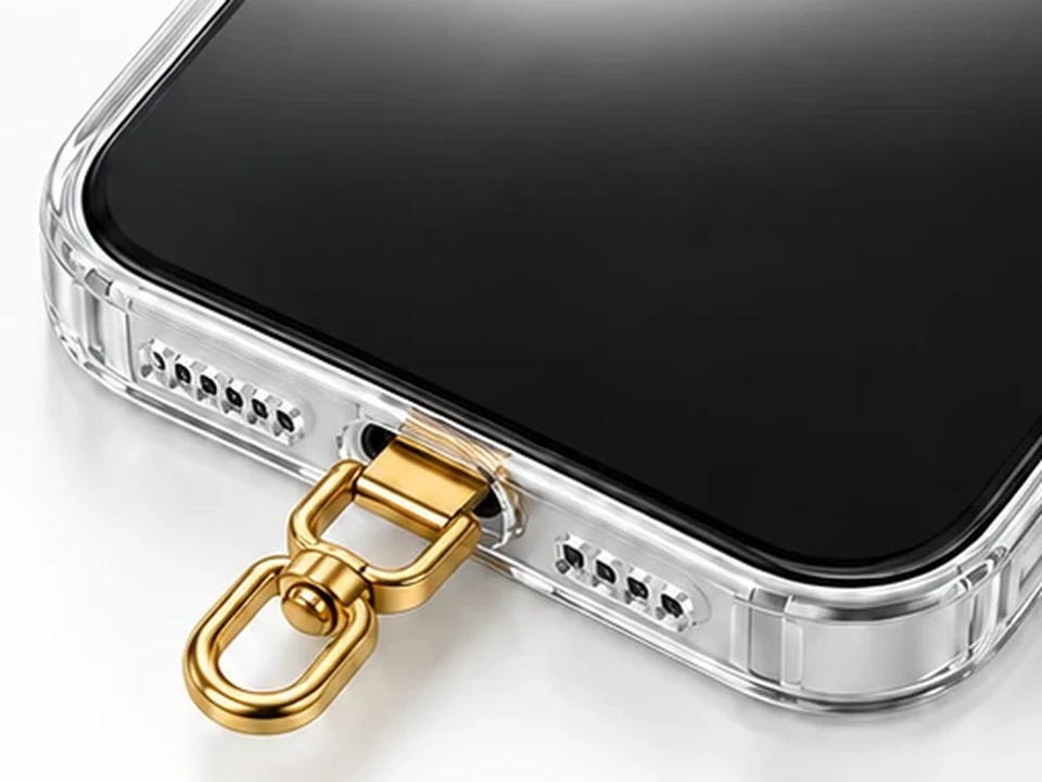 Móvil dentro de la funda transparente con la anilla del conector dorado saliendo por la abertura de carga